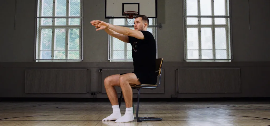 Man seated on a chair performing a rowing motion for shoulder release
